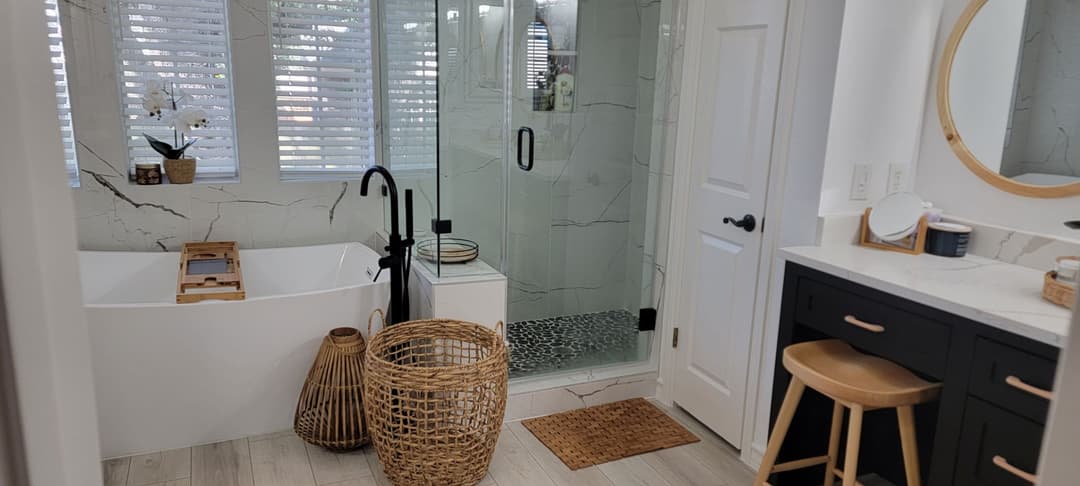 Modern bathroom with a freestanding tub, glass shower, and sleek natural decor elements.