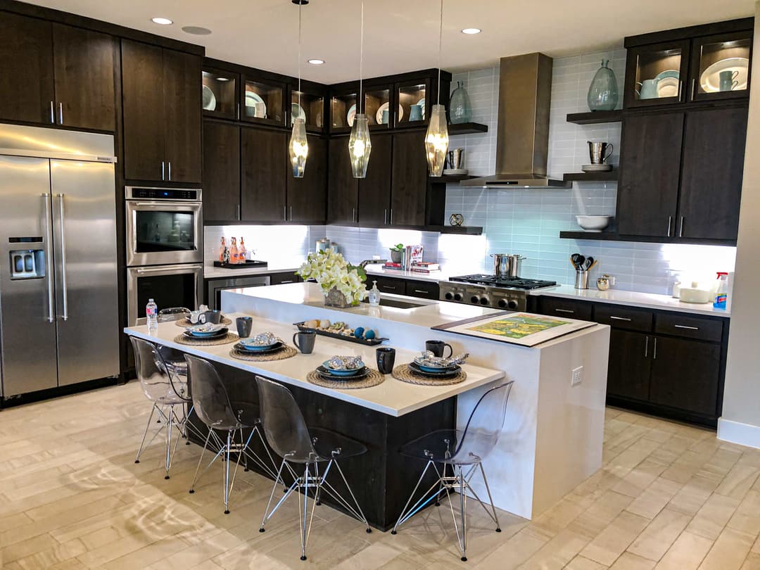 Modern kitchen with dark wood cabinets, stainless steel appliances, and elegant dining area.